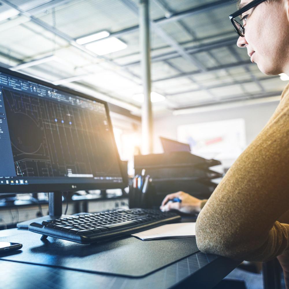 Engineer designing pharmaceutical equipment on desktop computer